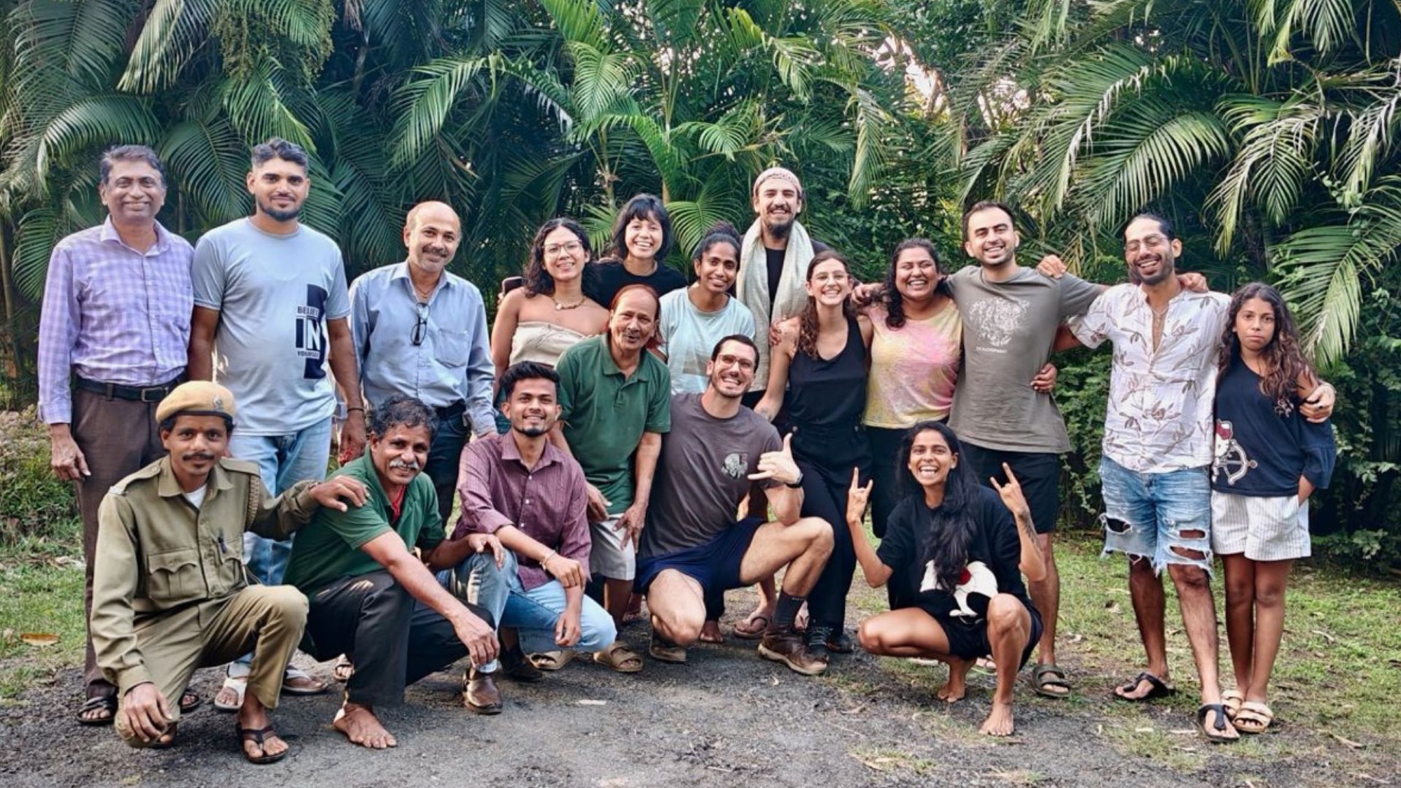 The cohort and the Jungli team together in front of the palms