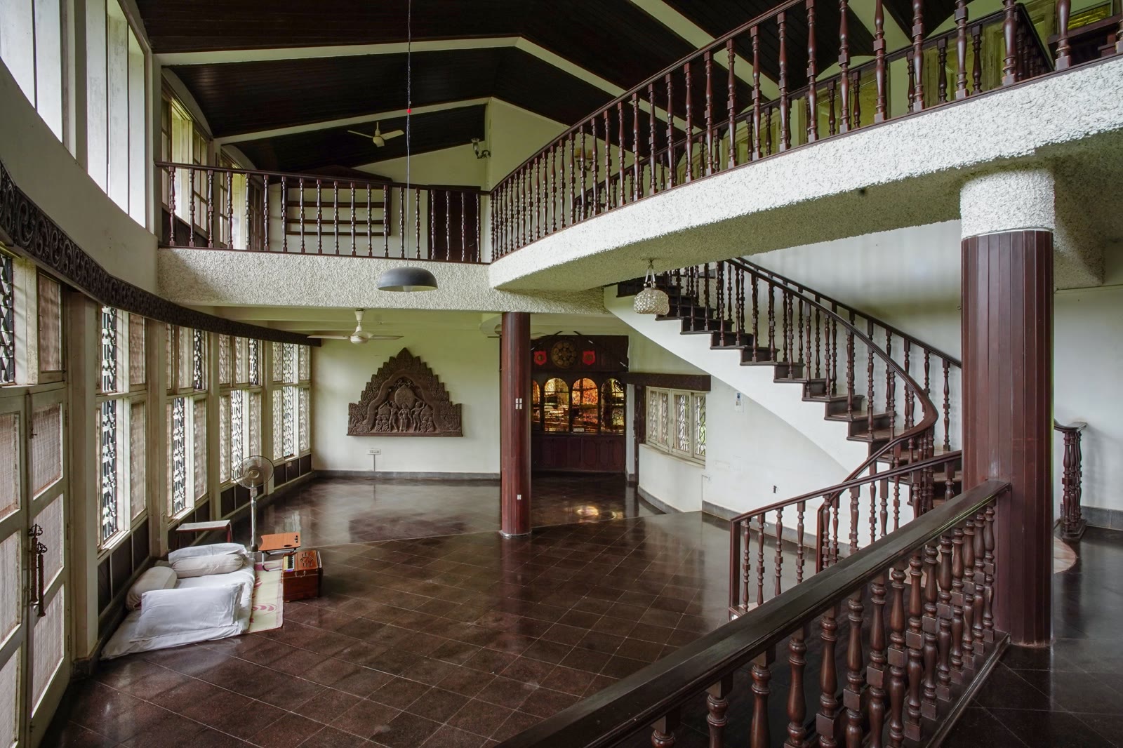 Grand double-height entry hall at Soch with carved wooden balcony and curved staircase