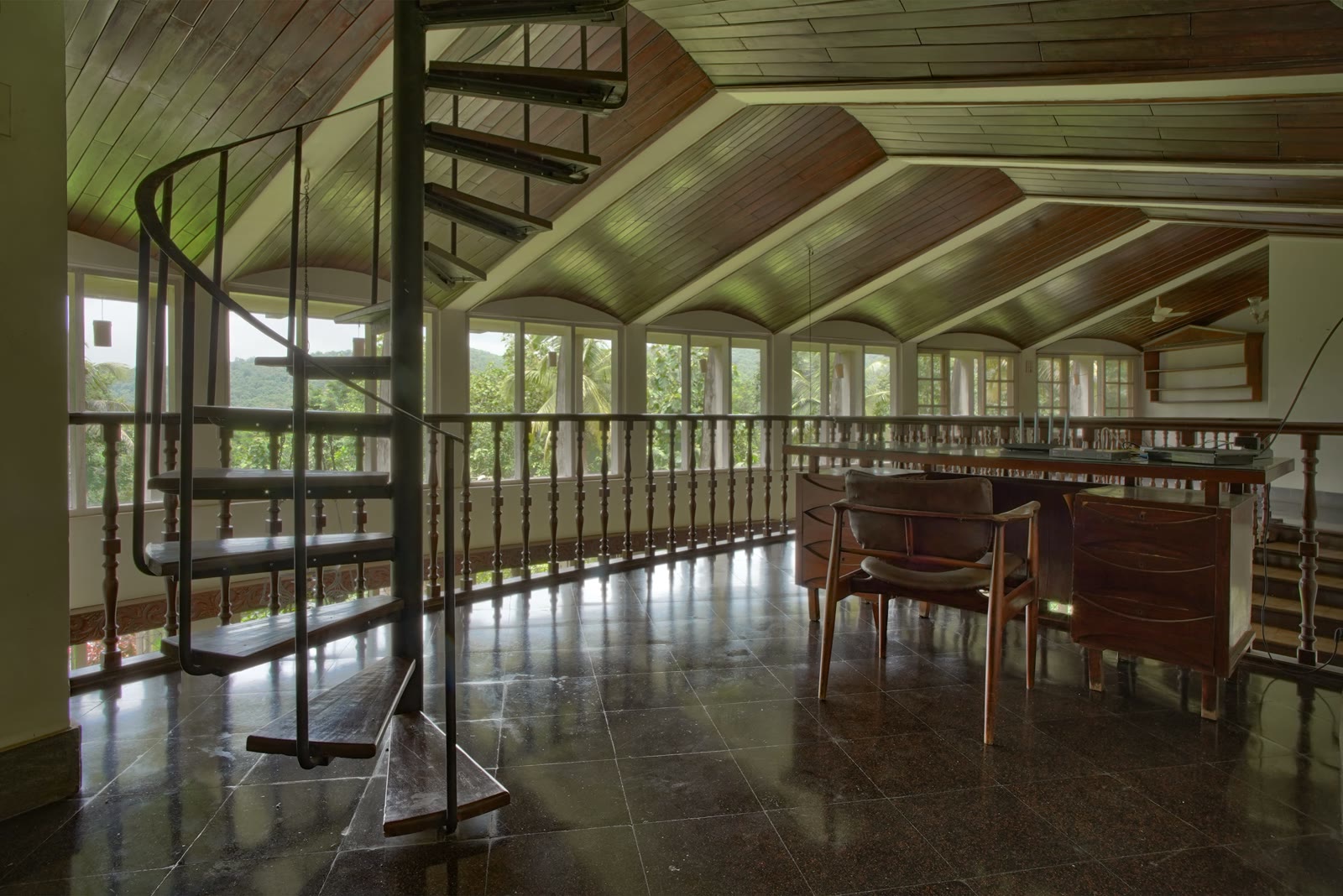 Upper mezzanine lounge at Soch, arched window wall looking into jungle, timber ceiling