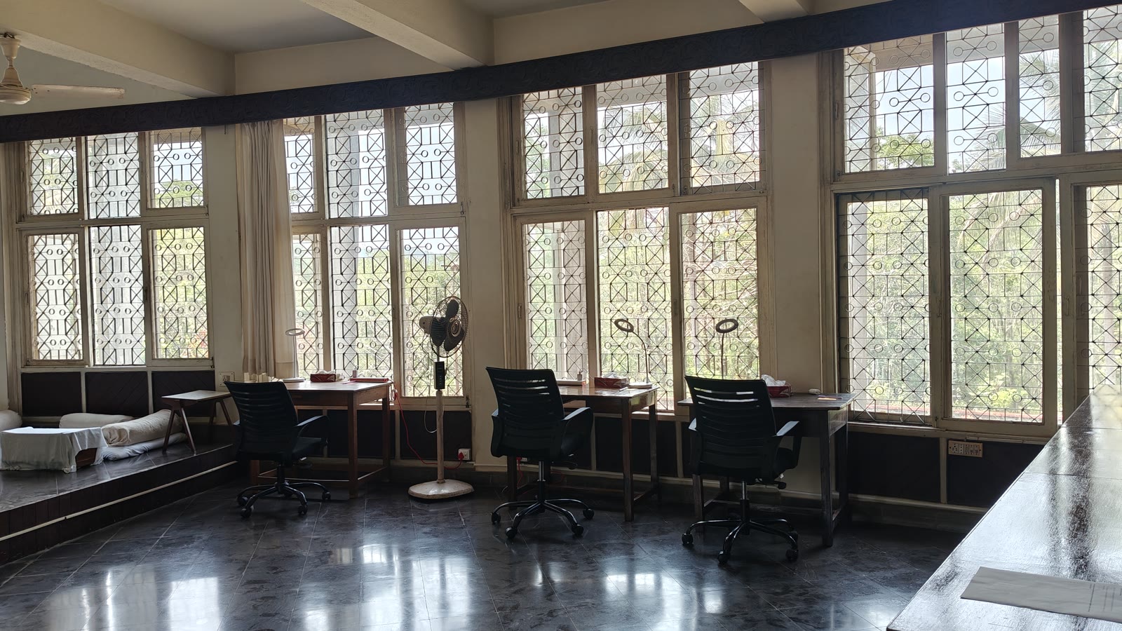 Coworking nook at Soch with desks lined against ornate latticed windows