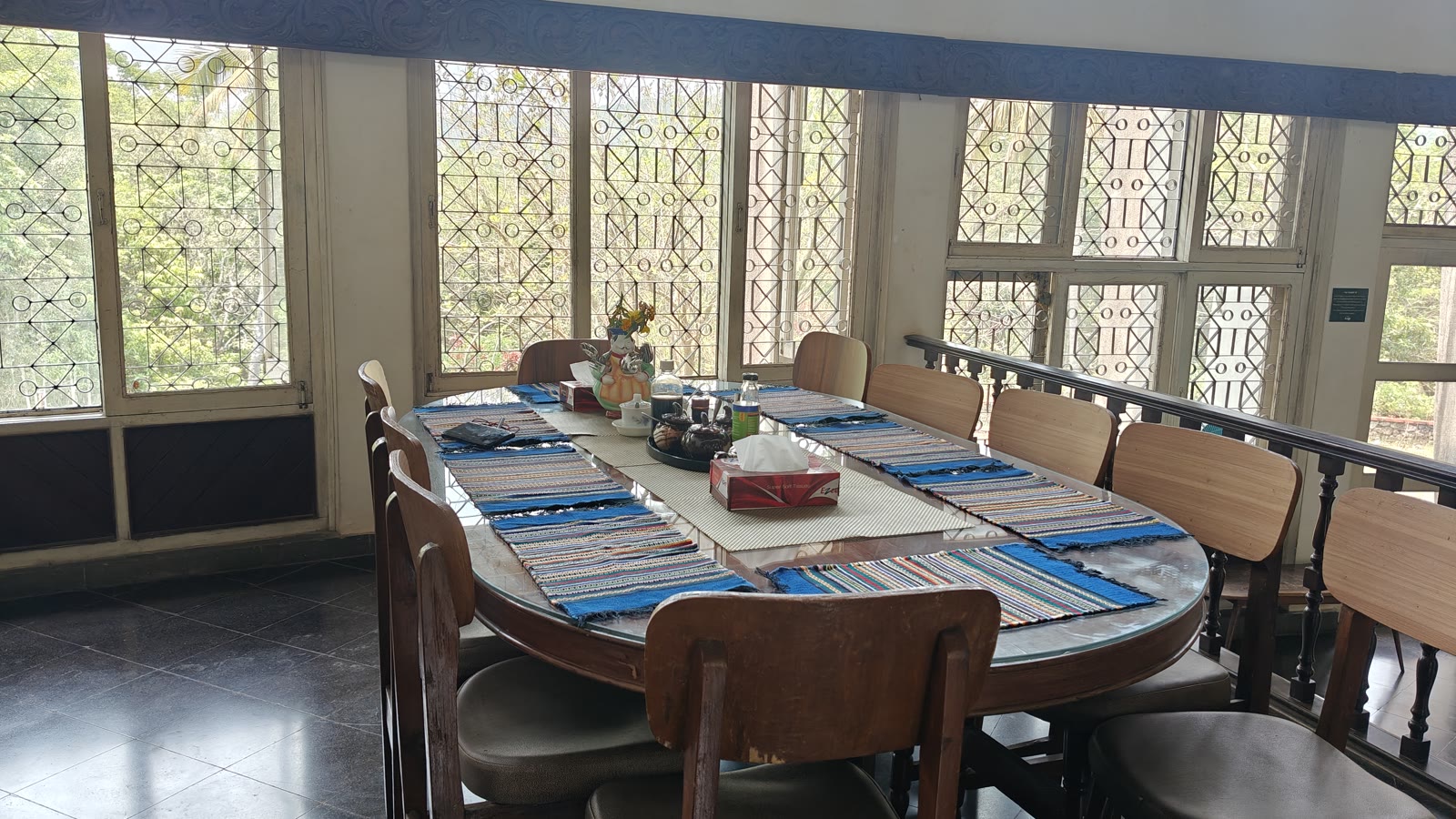 Dining table set with blue placemats against leaded glass windows at Soch