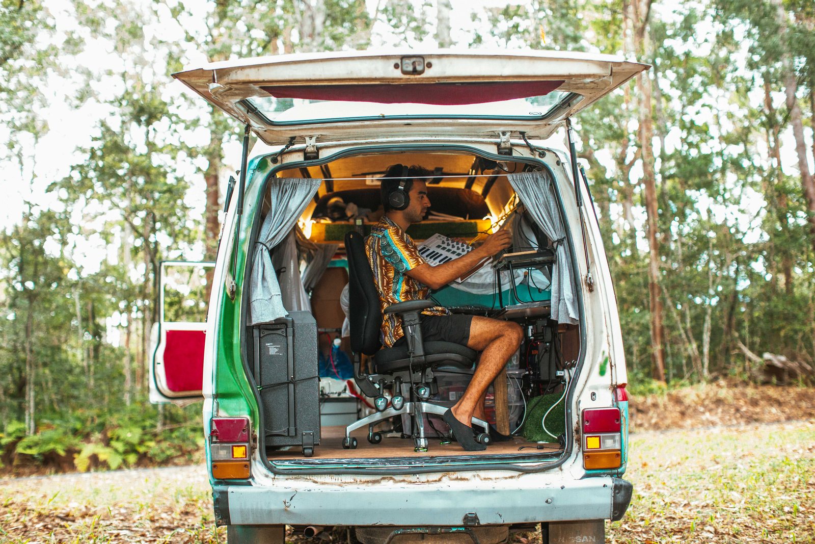 A production rig set up in the back of a van, forest on all sides